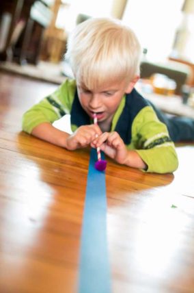 Blow pom poms along a line of tape