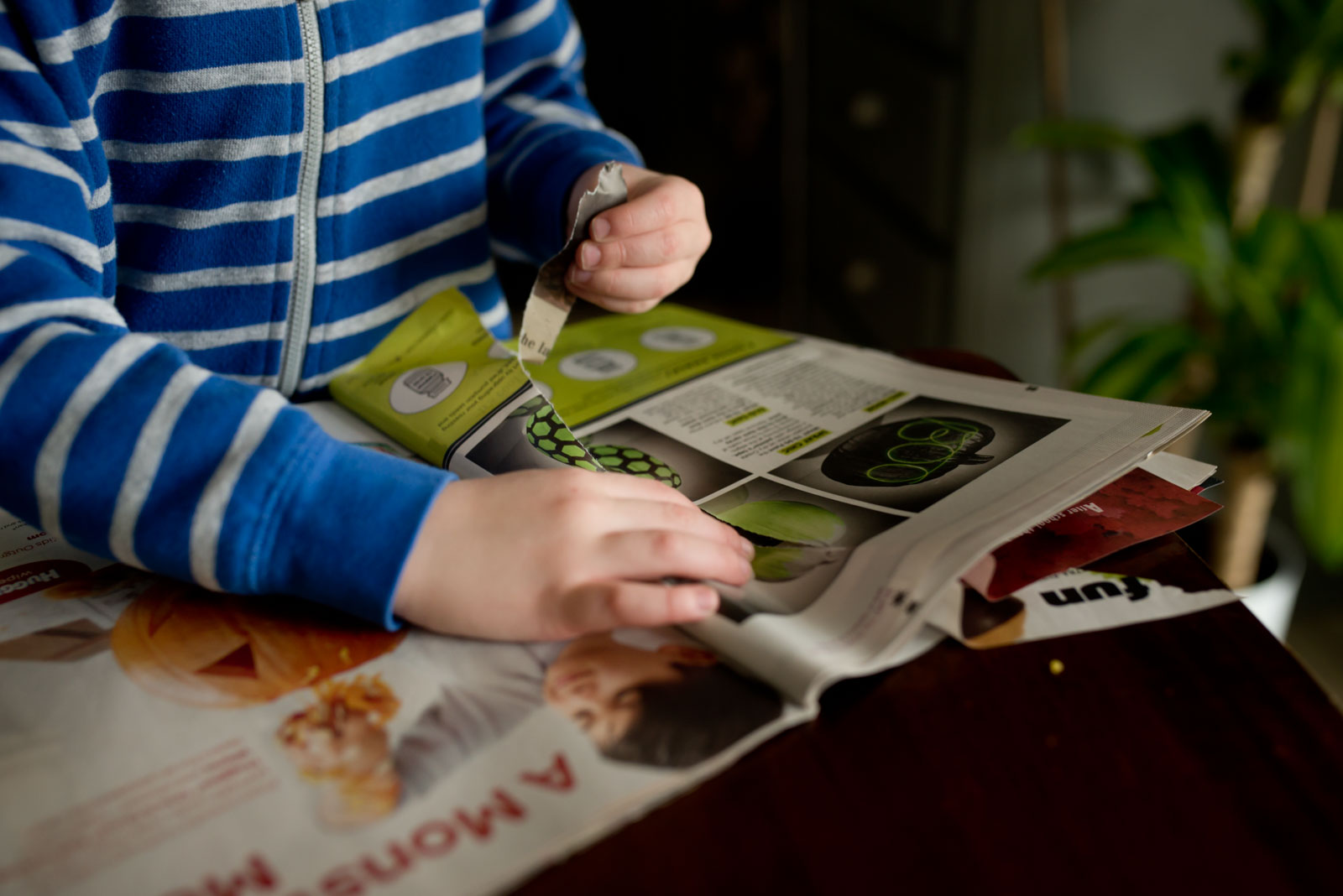 Tearing paper while going on a magazine scavenger hunt - a fine motor activity for preschoolers.