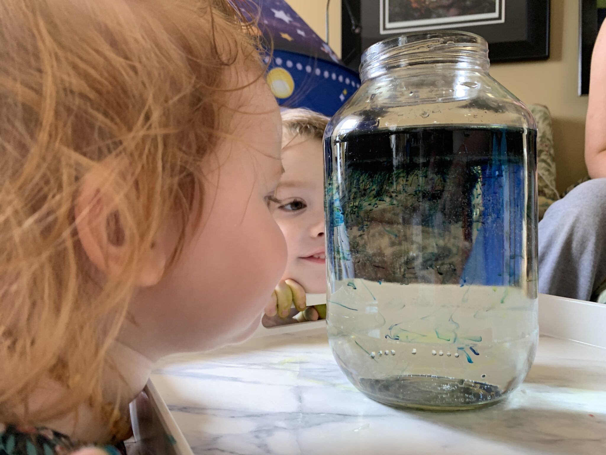 Create a galaxy of shooting stars in a jar space experiment for kids to do at home using simple household supplies from the kitchen!