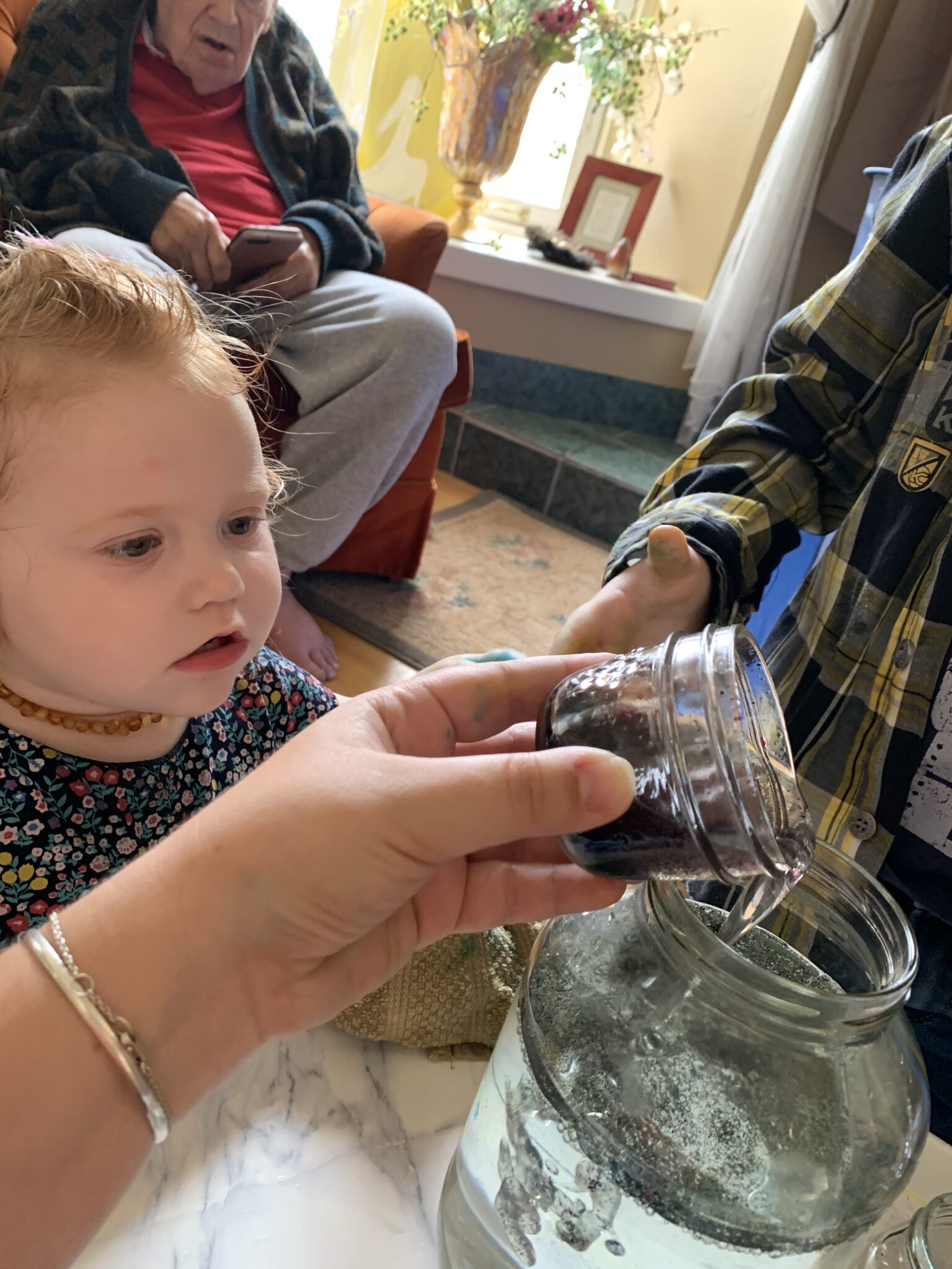 Pour in the food coloring and oil into the large jar to create your outer space shooting stars science experiment for kids.