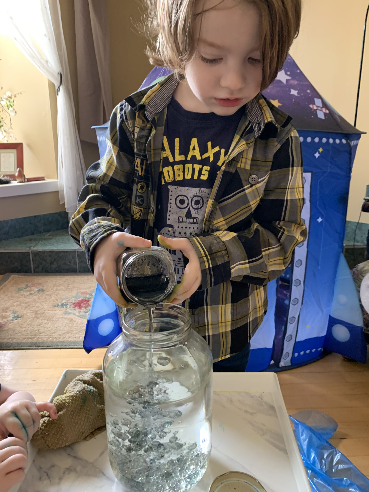 Pour the mixed up food coloring and oil into large jar of water.